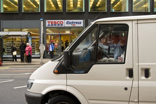 Thumbs up from man in delivery van in fron of Tesco express on London Road in Manchester city center