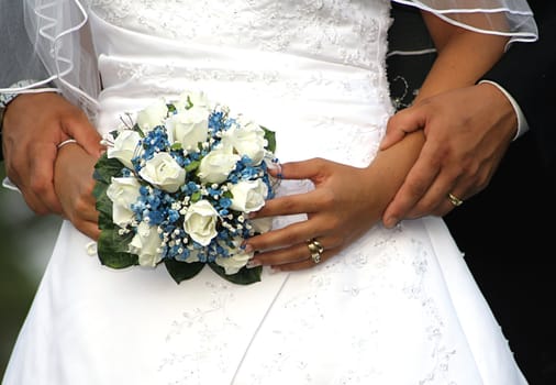 Bride and Grooms hands and bouquet on their wedding day

