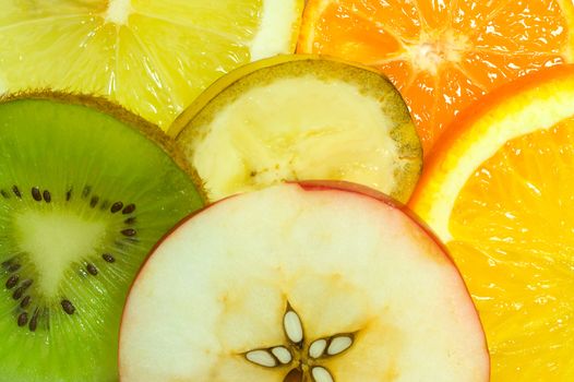 fruits background from slices apple, kiwi, tangerine, banana, lemon and orange