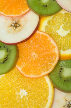 fruits background from slices kiwi, apple, tangerine and orange