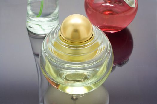 three bottles of perfume on mirror table