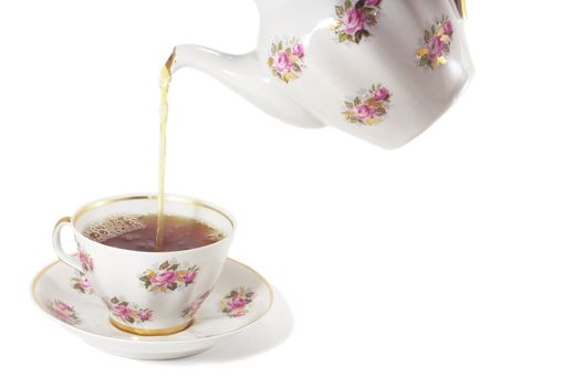 tea pouring from a china pot into a china cup