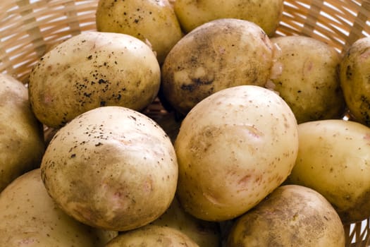 Fresh potatoes piled in a wicker basket