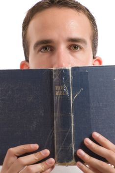 A young man reading the Holy Bible, isolated against a white background