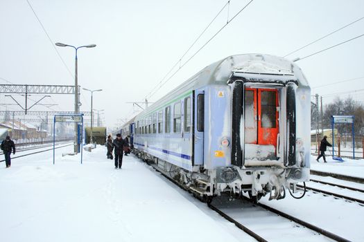 Passenger train at the station platform during heavy winter
