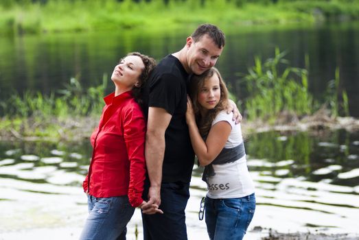 Portrait of parents with teenager daughter relaxing on nature