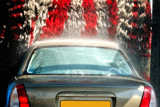  	

The car on the automatic washing with large rotating brushes