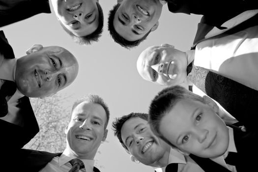 A groom and his groomsmen posing together in a huddle formation.