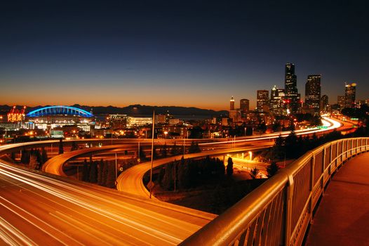 A night shot of freeways and Seattle downtown at the background