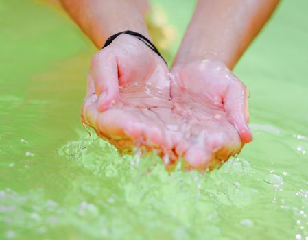 Woman's hands playing with fresh water