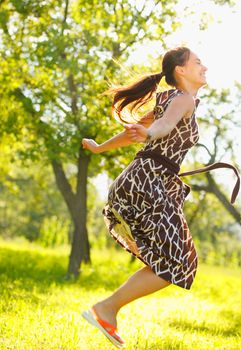 Young beautiful woman jumping in a meadow