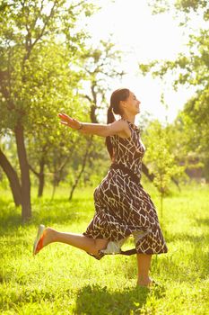 Young beautiful woman jumping in a meadow