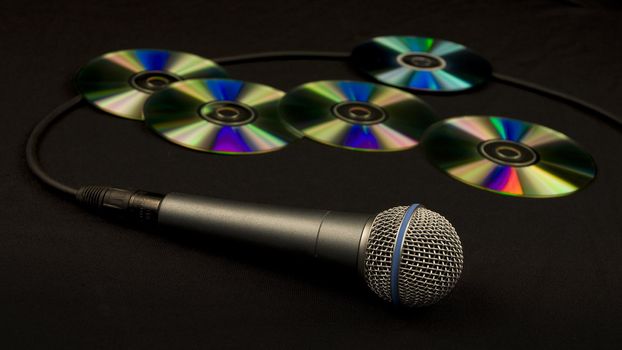 a microphone with many compact discs on the background