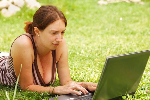 Young woman using her laptop outdoors.