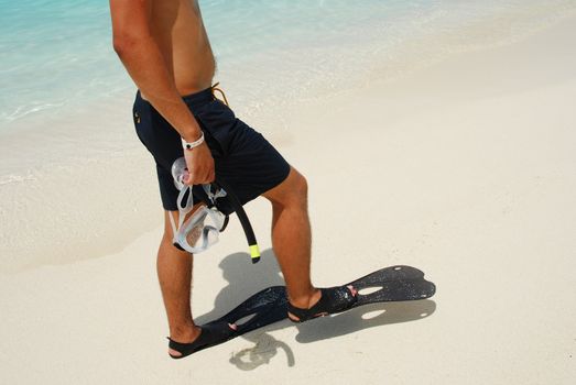 man getting ready to go snorkeling in a tropical island