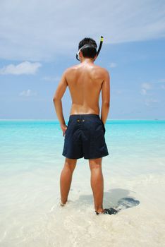 man getting ready to go snorkeling in a tropical island