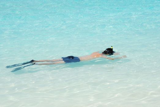 young man snorkeling in a tropical island