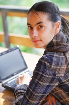 Young woman using her laptop outdoors.