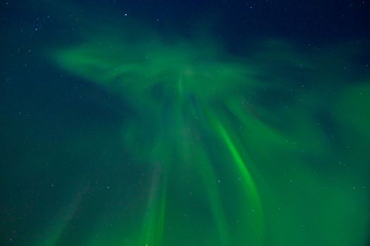 Clear night sky with lots of stars and dancing northern lights (Aurora borealis).