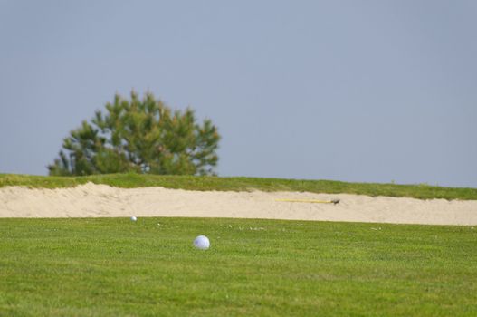 two ball of golf near a sand bunker