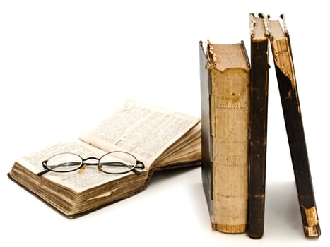 old books and glasses against white background 