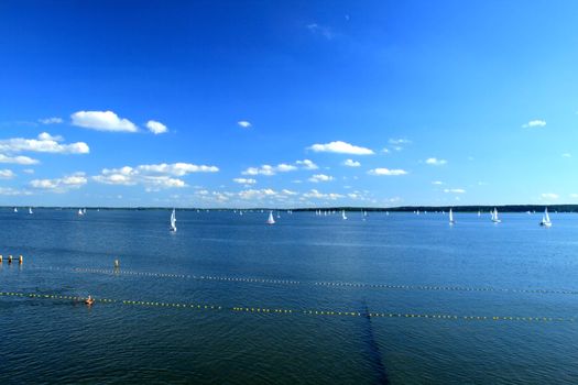 Yachts sailing on the lake under colorful sky
