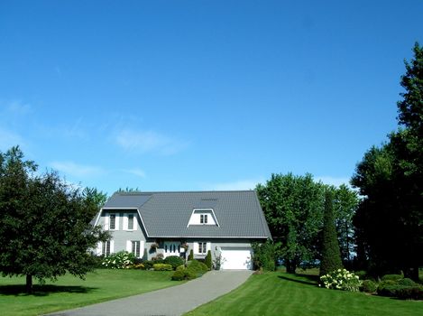 White house and cropped lawn and vegetation with deep blue sky