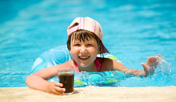 Little girl drinking soda in pool summer holidays