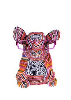 Small stuffed elephant wearing glasses sitting up