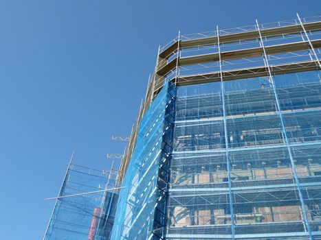 Side of scaffolding on building by beautiful blue sky