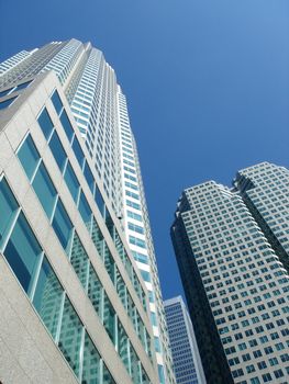 Buildings photographed from below with deep blue sky