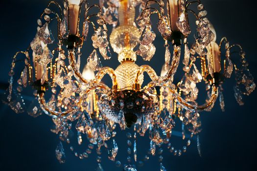 Elegant crystal chandelier hanging against blue background