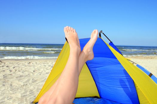 Beautiful woman with crossed legs resting on the beach
