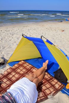 Beautiful woman with crossed legs resting on the beach
