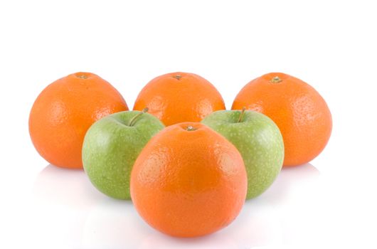 Apples and oranges in bowling line-up, isolated white.