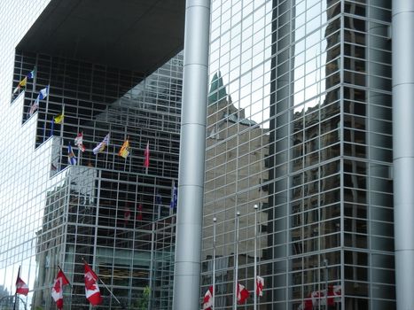 Modern building made of galsses in Ottawa, Canada, with flags