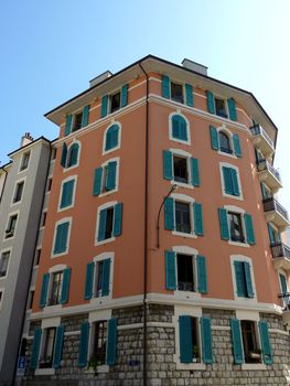 Colored building with green shutters by beautiful weather