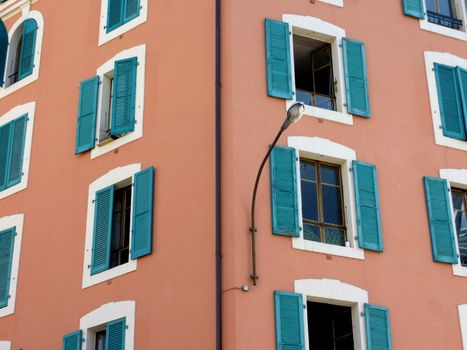 Close-up of green shutters on colored facade