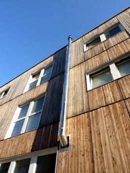 Metallic chimney on a wood facade by beautifull weather