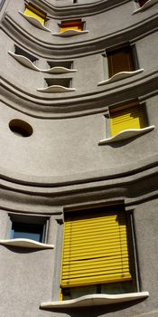 Detail of a colored facade of a building with yellow shutters