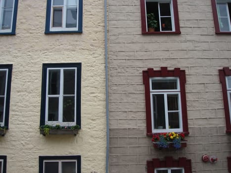 Windows with different color of the frame on wall in old Quebec, Canada