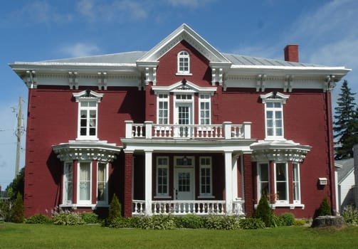 Historical red house in Yamachiche by beautifull weather in Quebec, Canada