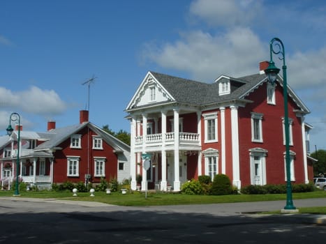 Red historical houses in Yamachiche Quebec, Canada, by beautiful weather