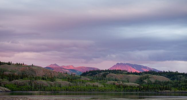 Distant mountains glowing in sunset light  at Lake Laberge, Yukon Territory, Canada.