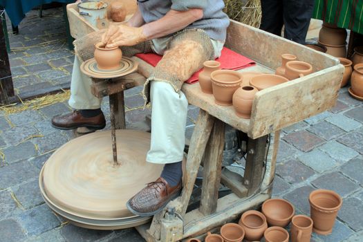 Man making a loam pottery at a market
