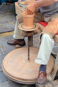 Man making a loam pottery at a market
