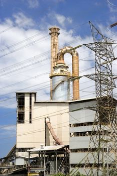 Image of a cement factory with electrical power pylons and cables in Malaysia.