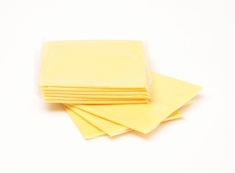 A stack of processed cheese slices over white background.