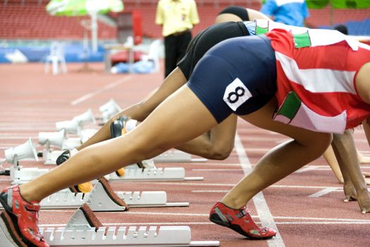 Image of 100 meter athletes at the starting block.