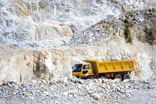 Image of a yellow truck at a rock quarry in Malaysia.